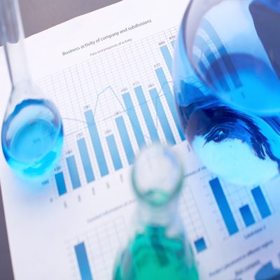 Test-tubes with blue liquids over business document